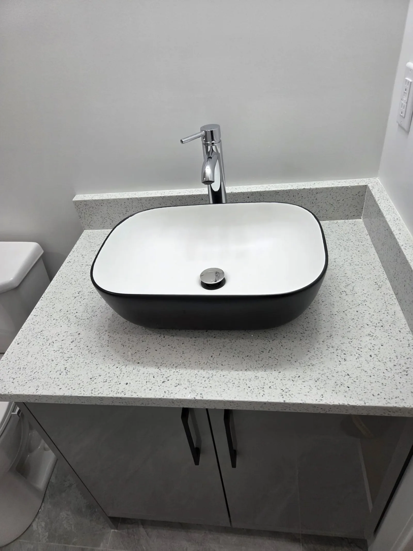Black vessel sink on a quartz vanity countertop — Calgary bathroom