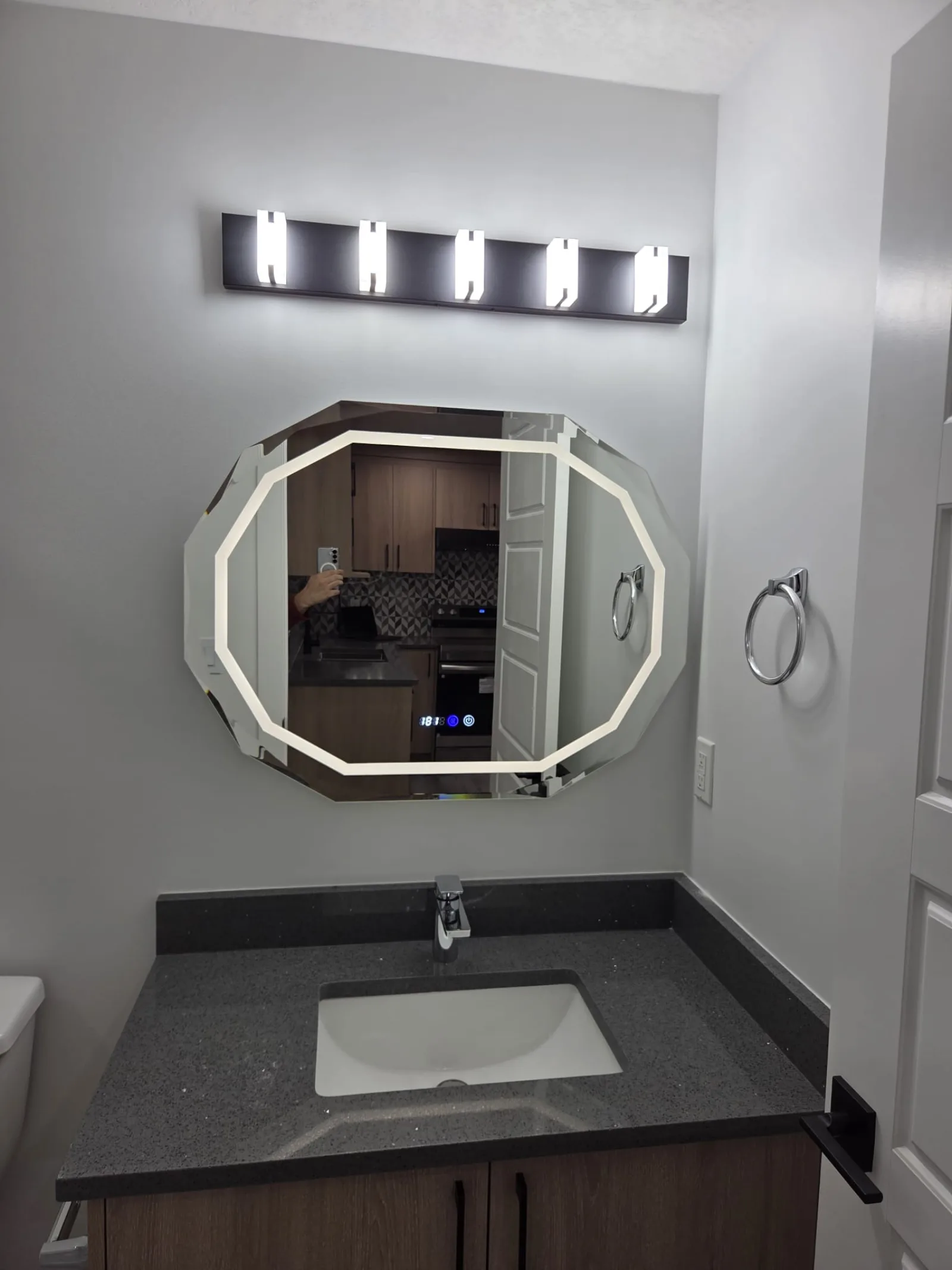 Bathroom vanity with octagonal backlit mirror and quartz countertop — Calgary